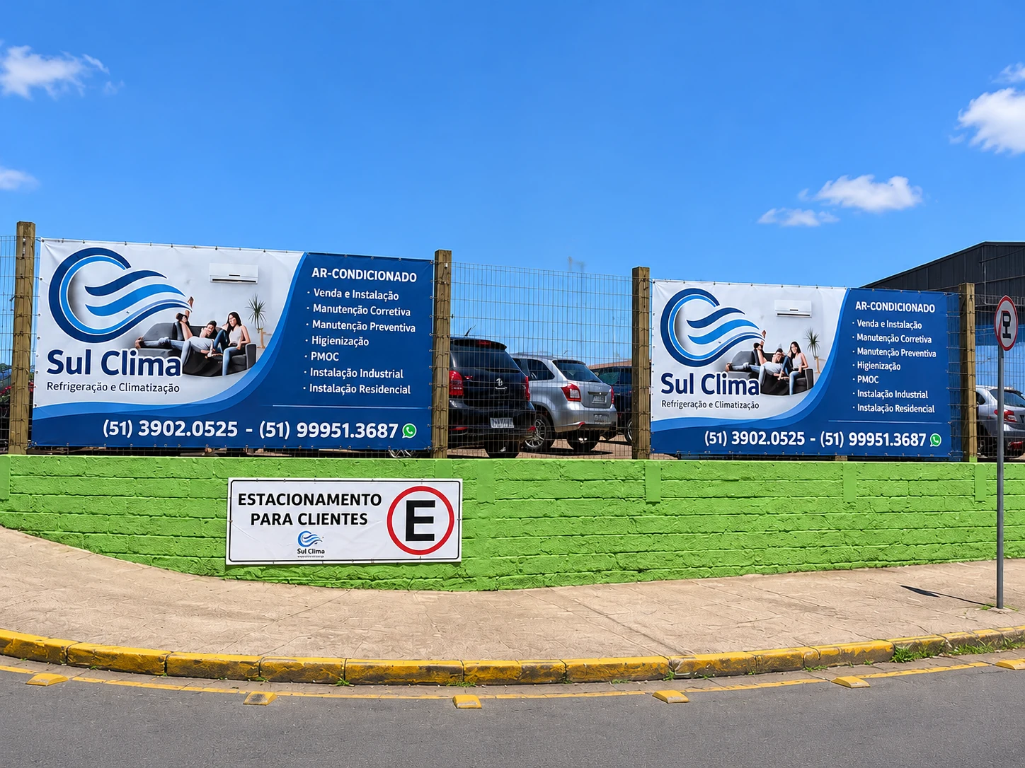 Estacionamento da Sul Clima com banners da empresa e placa de vagas para clientes